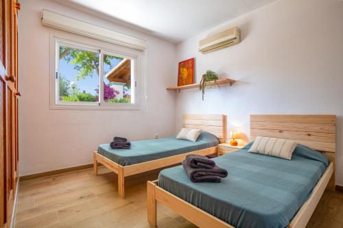 a bedroom with two beds and a window at Casa Can Ferran in Nuestra Señora de Jesus
