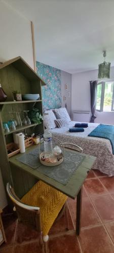 a room with a bed and a table in a room at La clé des champs in Asnières
