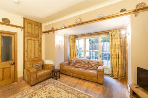 a living room with a couch and a chair at Bridge Cottages, Bridge House & Bridge Suite, Sleeps 12 in Coniston