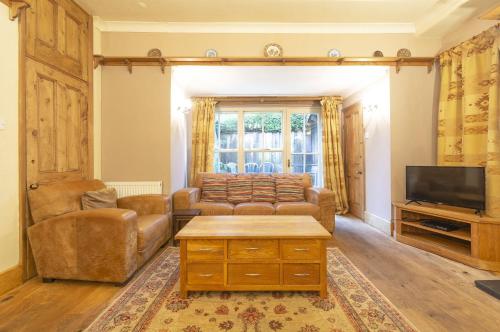 a living room with a couch and a tv at Bridge Cottages, Bridge House & Bridge Suite, Sleeps 12 in Coniston