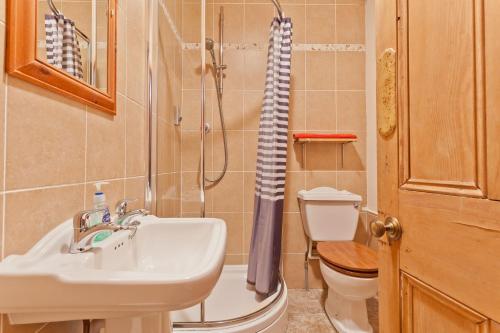 a bathroom with a sink and a toilet and a shower at Bridge Cottages, Bridge House & Bridge Suite, Sleeps 12 in Coniston