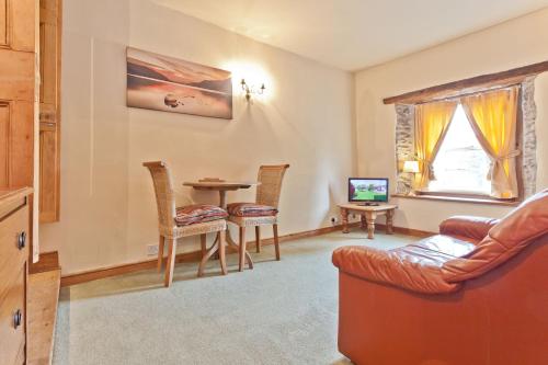 a living room with a couch and a table at Bridge Cottages, Bridge House & Bridge Suite, Sleeps 12 in Coniston