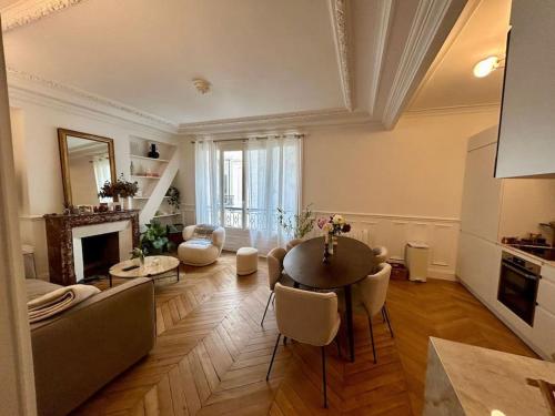 ein großes Wohnzimmer mit einem Tisch und Stühlen in der Unterkunft Blanche house près du Moulin rouge in Paris