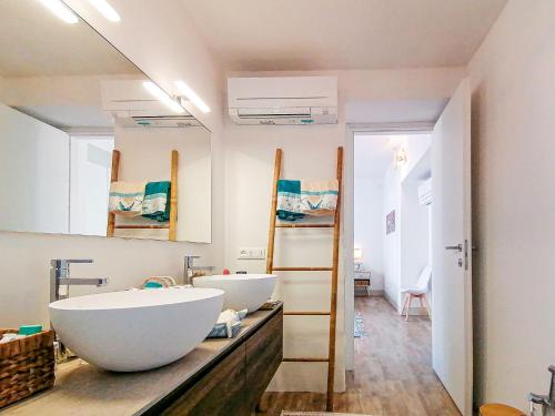 a bathroom with a large white tub and a sink at Layla Luxury Home in Santa Teresa Gallura