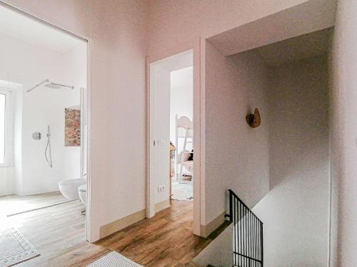 una camera bianca con corridoio e scala di Layla Luxury Home a Santa Teresa di Gallura