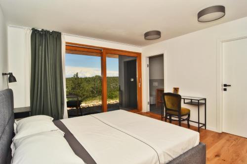 1 dormitorio con cama, escritorio y ventana en Luxury Villa Vela Baraka with Heated Pool en Dragove