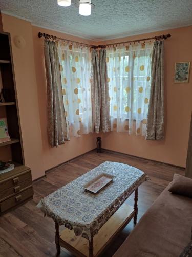 - un salon avec une table et 2 fenêtres dans l'établissement Holiday Home Milkovci, à Gabrovo