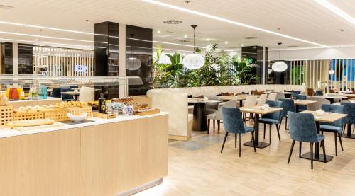 a restaurant with blue chairs and tables and a bar at Ilunion Barcelona in Barcelona