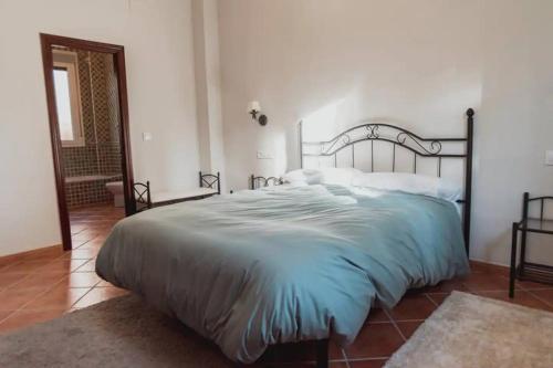 um quarto com uma cama grande e uma cabeceira de metal em Casa del Brezo em Córdoba