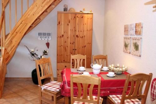 ein Esszimmer mit einem Tisch, Stühlen und einer Treppe in der Unterkunft Ferienwohnung Hanni in Heringsdorf