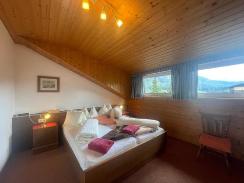 um quarto com uma cama grande num quarto de madeira em Ferienwohnungen im Haus Sonnleiten am Weissensee em Techendorf