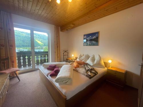a bedroom with a large bed with a window at Ferienwohnungen im Haus Sonnleiten am Weissensee in Techendorf