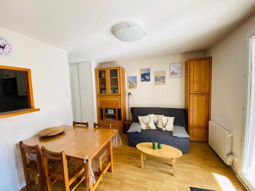 un salon avec un canapé bleu et une table dans l'établissement La Marmotaine, T2 bis, Parking privé, Balcon vue montagne, à Luchon