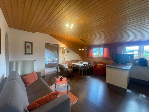 a living room with a couch and a dining room at Ferienwohnungen im Haus Sonnleiten am Weissensee in Techendorf