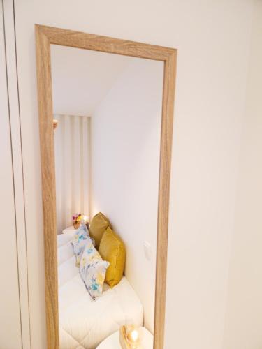 a mirror reflecting a white couch in a room at RAIO FLAT in Braga