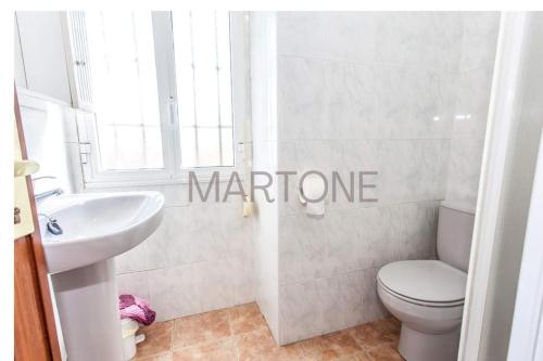 a white bathroom with a toilet and a sink at Casa Vacacional Vigo Planta Baja in Vigo