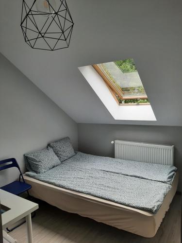 a bedroom with a bed and a skylight at Pokoje gościnne OSKAR in Łeba