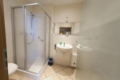 uma casa de banho com um chuveiro, um lavatório e um WC. em Hotel Obermühle em Görlitz