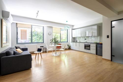 Bright 2BDR Apartment Downtown Exarcheia! في أثينا: غرفة معيشة مفتوحة مع أريكة ومطبخ