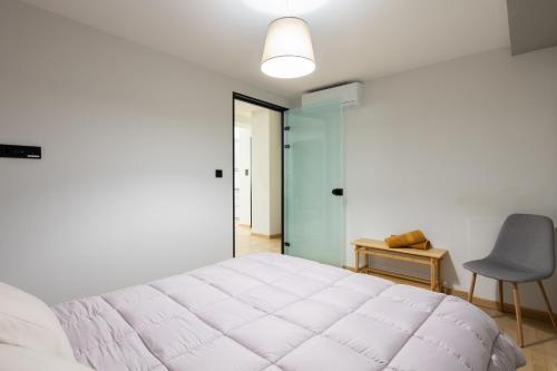 Bright 2BDR Apartment Downtown Exarcheia! في أثينا: غرفة نوم بسرير ابيض كبير وكرسي