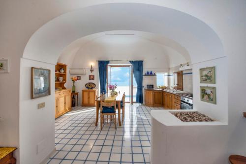 a kitchen with an archway and a table with chairs at Casa Rosamare, 150 steps from the road in Praiano