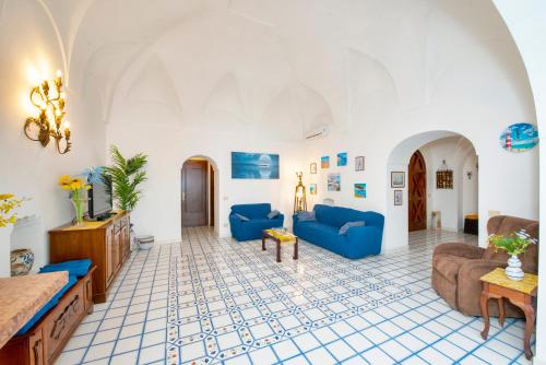 a living room with blue couches and a tile floor at Casa Rosamare, 150 stairs from the road by Wonder Tour in Praiano