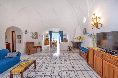 a living room with a tv and a couch at Casa Rosamare, 150 stairs from the road by Wonder Tour in Praiano
