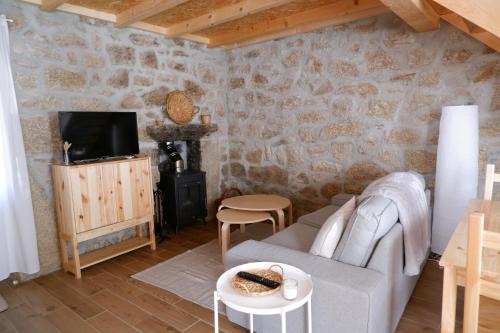 a living room with a couch and a tv at Casa da Rabita in Capinha
