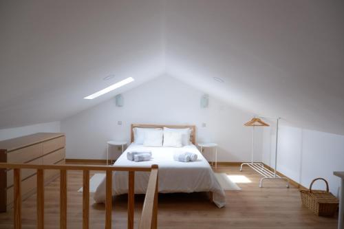Casa da Rabita في Capinha: غرفة نوم بسرير ابيض وارضية خشبية