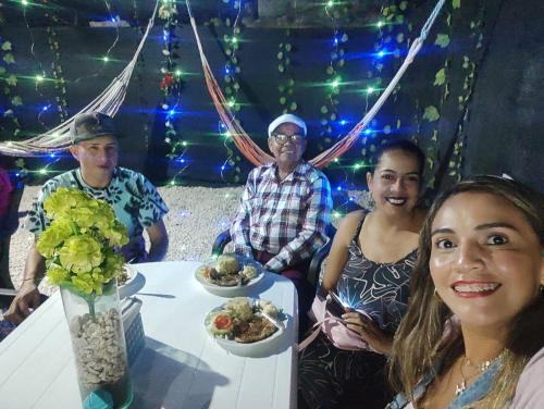 a group of people sitting around a table with food at HOTEL HERMOSO CARIBE in Tolú