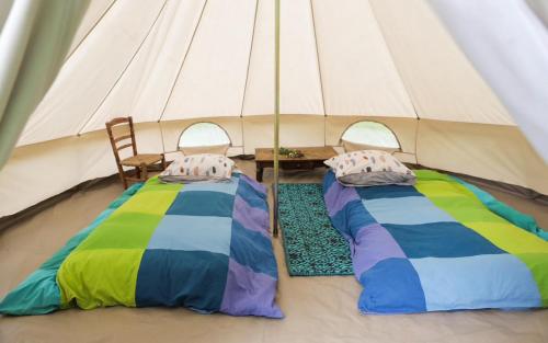 two beds in a tent with a table and chairs at Tente style Tepee Confort in Latour-de-Carol