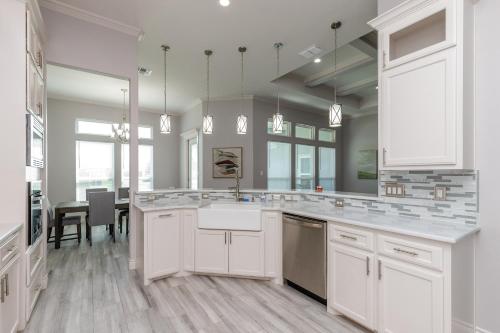 a kitchen with white cabinets and a dining room at Luxurious 4-Bedroom Retreat Near the Beach: King Suite, High-Speed WiFi, Free Parking in Corpus Christi