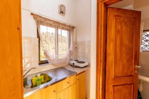 a kitchen with a sink and a window at Skioni Studios in Nea Skioni