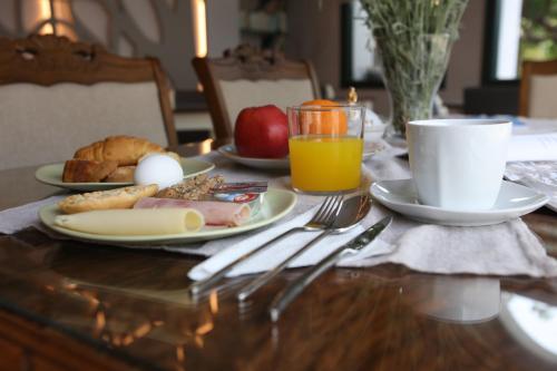 a table with a breakfast of eggs bread and fruit at Kalimera Andros in Andros