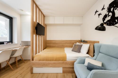 1 dormitorio pequeño con 1 cama y 1 sofá azul en Apartments Gros, en Radeče