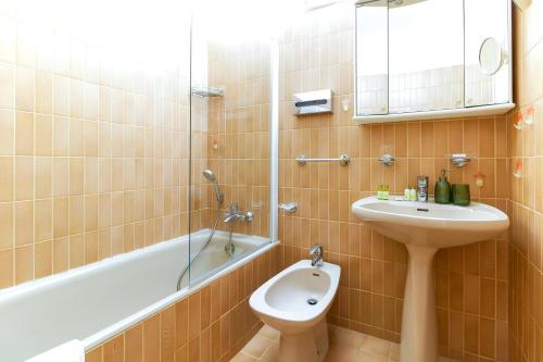 a bathroom with a sink and a toilet and a bath tub at SELECT'soHOME - Superbe Duplex dans le quartier Saint-Clair au Lavandou - PARCFO16 in Le Lavandou