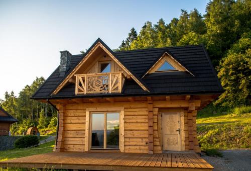 a log cabin with a black roof at Domek Wilk w Górach Sowich in Jugów