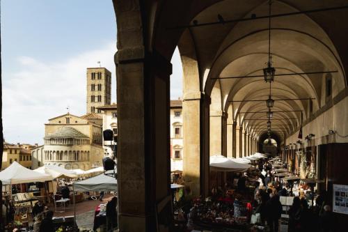 a group of people walking around a market in a building at Sopra Le Poste in Arezzo