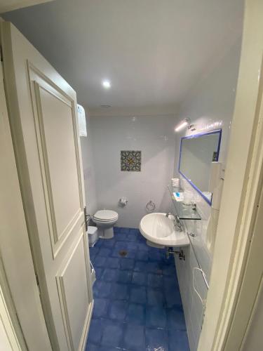 a bathroom with a white sink and a toilet at Hotel America in Marina di Camerota