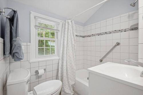 Baño blanco con aseo y lavamanos en Arlington Colonial Oasis: 15-Minute Drive to Washington DC, en Arlington