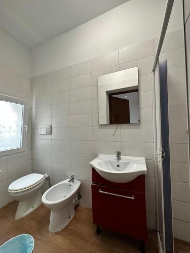 a white bathroom with a toilet and a sink at Dream holiday in Mestre