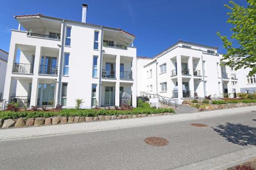 two white buildings on the side of a street at Villa Antje - Ferienwohnung 03 in Göhren