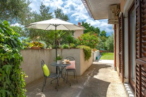 a table and chairs with an umbrella on a patio at Apartment Alex in Labin