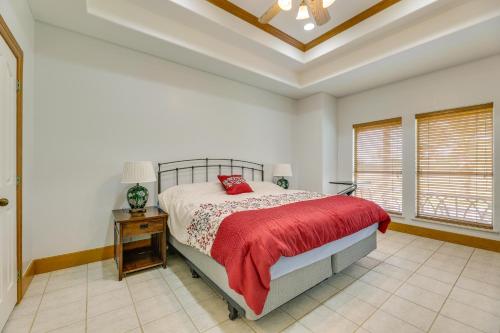 a bedroom with a bed with a red blanket and a table at Laguna Vista Vacation Rental with Pool Access! in Laguna Vista
