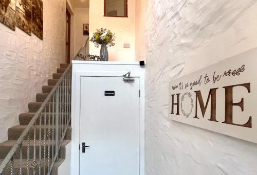 a white door in a hallway next to a staircase at Burnside in Tighnabruaich