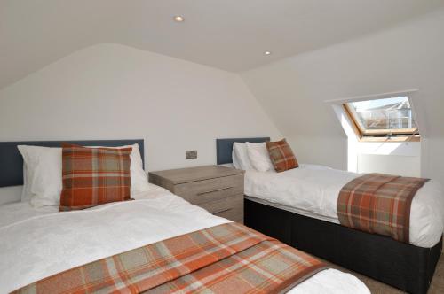 two beds sitting next to each other in a bedroom at Burnside in Tighnabruaich