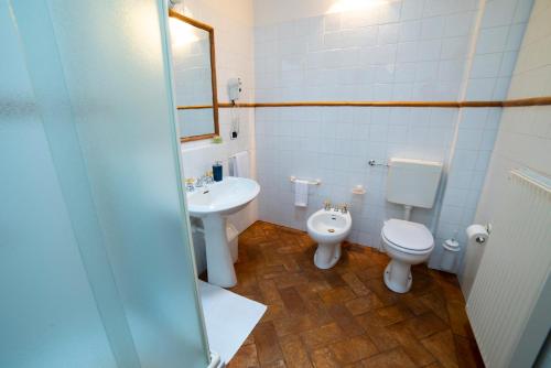 a bathroom with a toilet and a bidet and a sink at Volpe Pasini - Wine and Rooms in Togliano