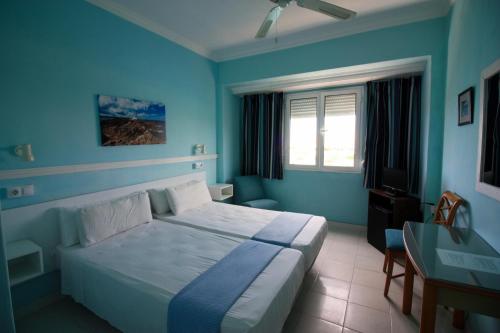 Dormitorio azul con cama y escritorio en Cala Bona y Mar Blava en Ciutadella