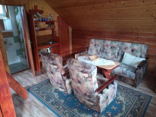 ein Wohnzimmer mit einem Tisch und 2 Stühlen in der Unterkunft Chatky u Hromádky in Karlovice