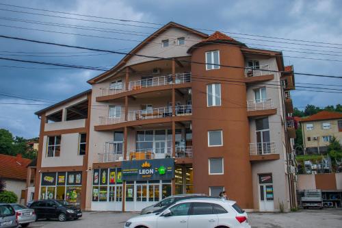 a building with cars parked in front of it at Apartmani Vrla in Vladičin Han